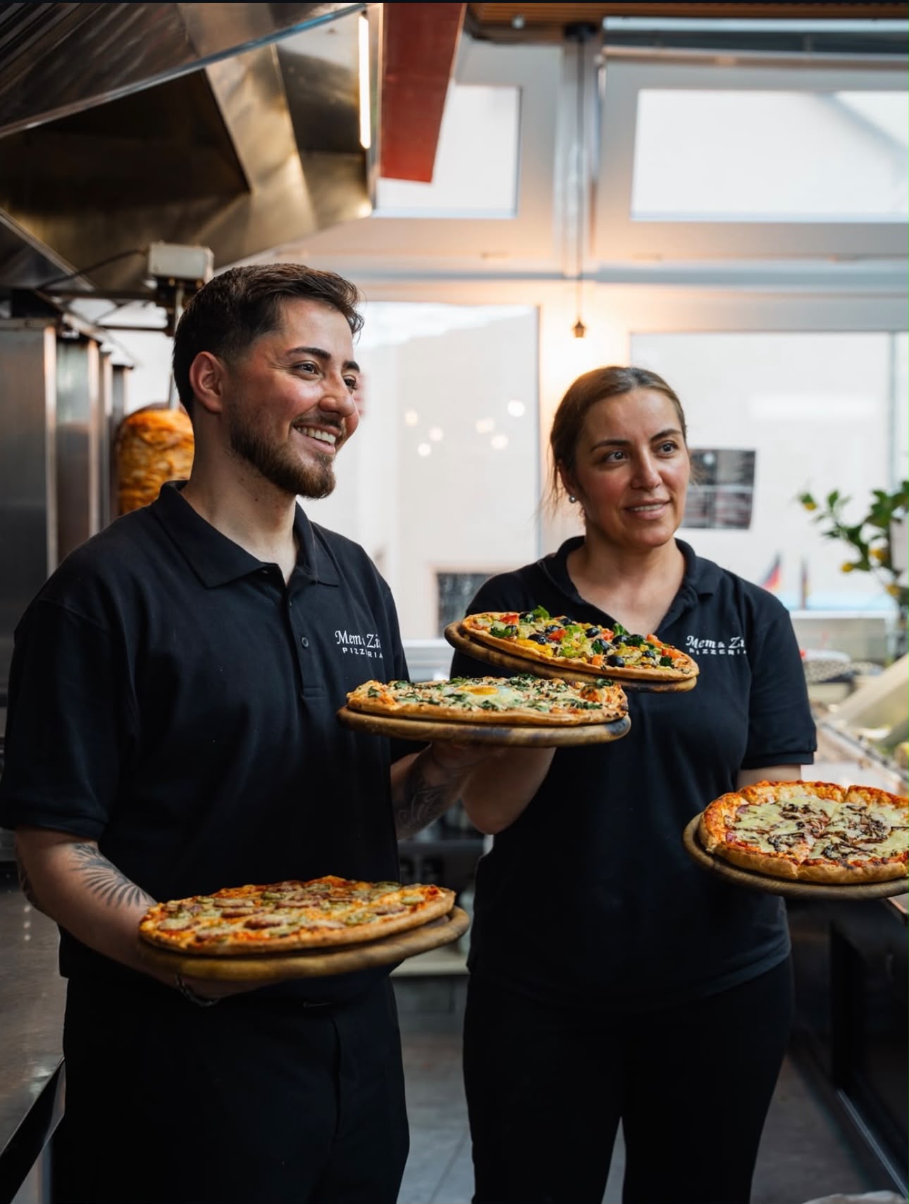 Das Team der Pizzeria präsentiert frische Pizzen